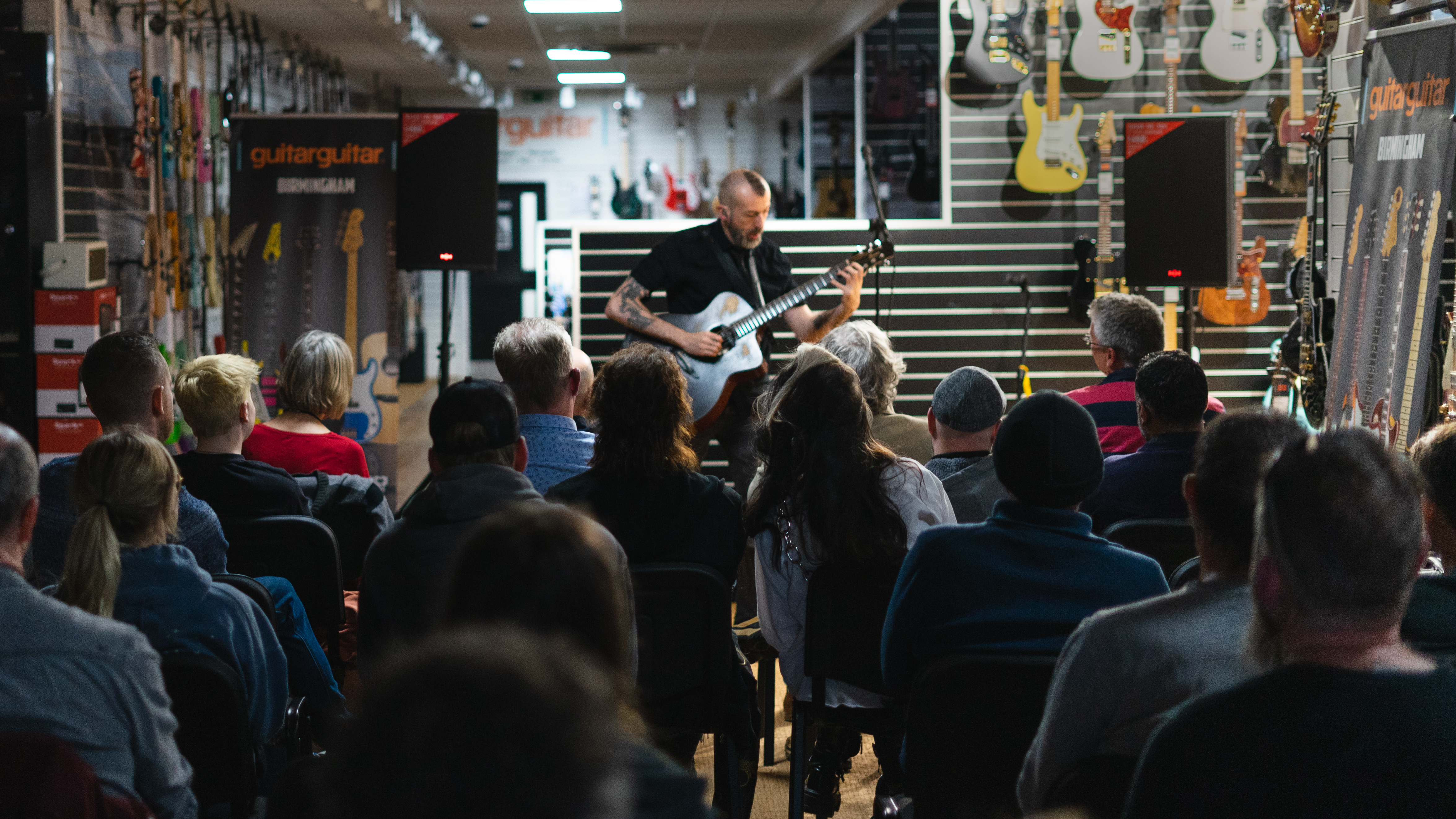 Jon Gomm performing at a guitarguitar store